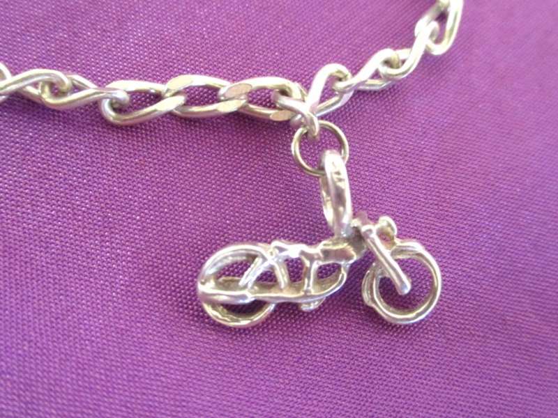 A SOLID SILVER CHARM BRACELET WITH EXTRA LARGER CHARMS