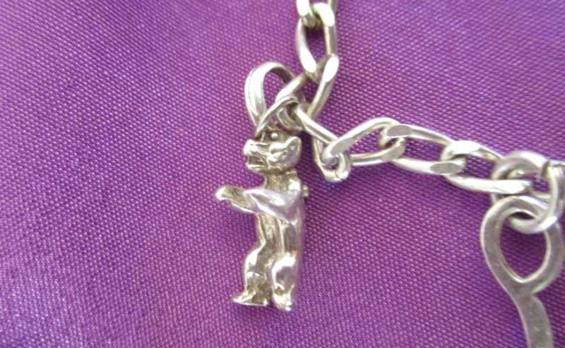 A SOLID SILVER CHARM BRACELET WITH EXTRA LARGER CHARMS