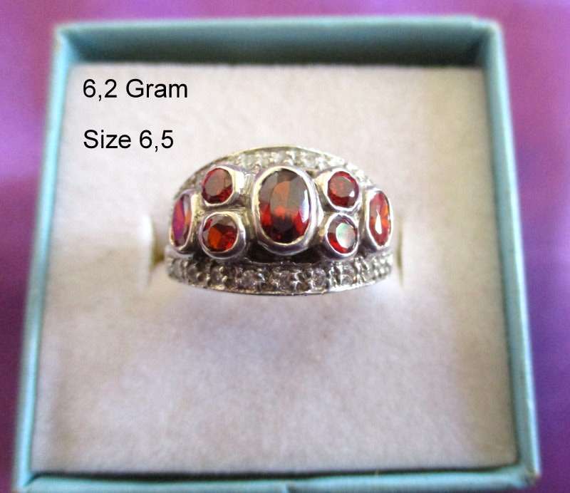 A SOLID SILVER RING WITH RED STONES