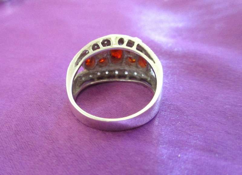 A SOLID SILVER RING WITH RED STONES