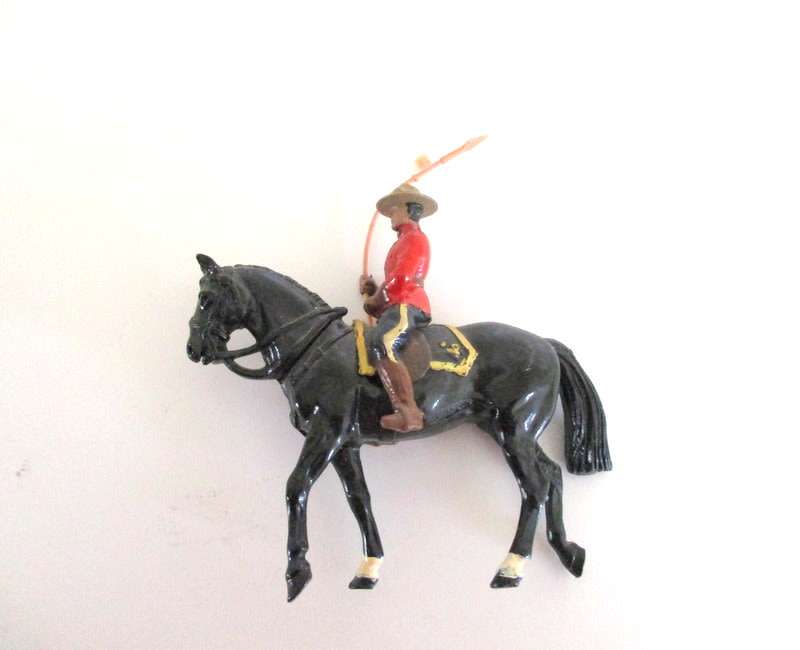 A VINTAGE LEAD CANADIAN MOUNTED POLICEMAN AND 2 LEAD DWARFS