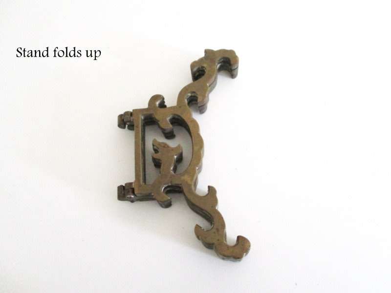 A VINTAGE BRASS PLATE EMBOSSED WITH FRUIT AND ETCHED CENTER ON A STAND