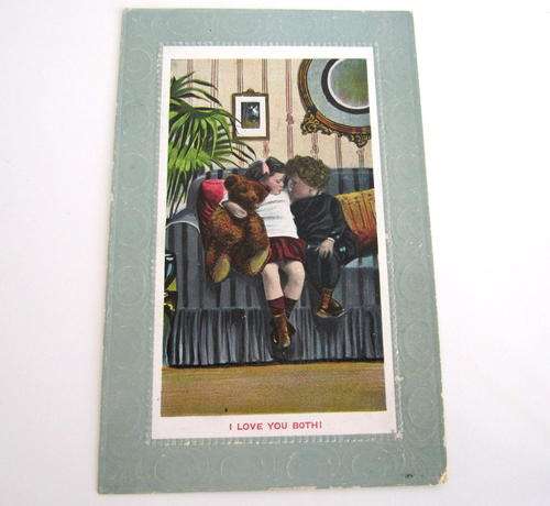 AN ANTIQUE POSTCARD OF A CHILD AND HER BEAR