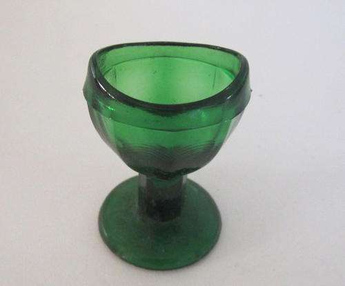 A GREEN GLASS PEDESTAL EYE RINSER