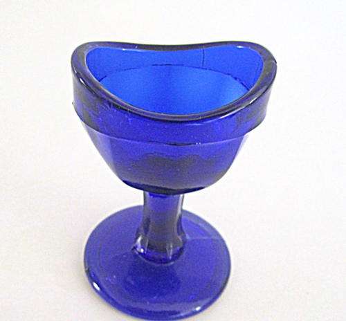 A BLUE GLASS PEDESTAL EYE RINSER