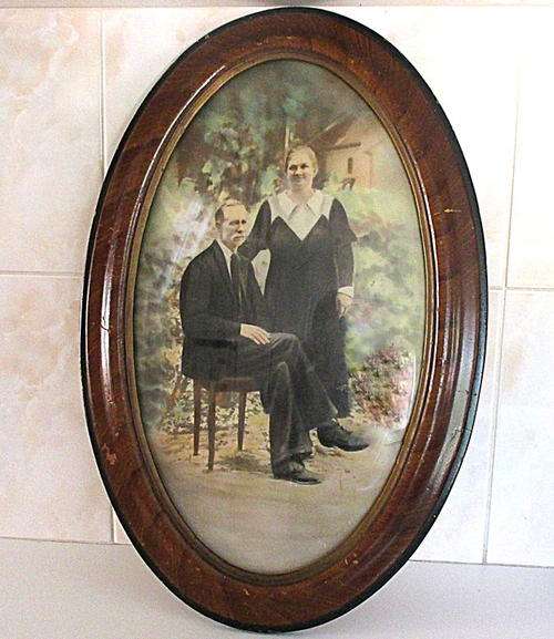 A LARGE ANTIQUE OVAL FRAME WITH CONVEX GLASS WITH A PHOTO