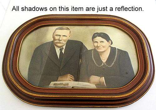 A LARGE ANTIQUE OVAL FRAME WITH CONVEX GLASS WITH A PHOTO