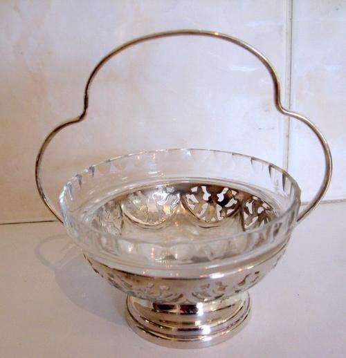 A SILVER PLATED BASKET WITH A CRYSTAL BOWL INSERT.