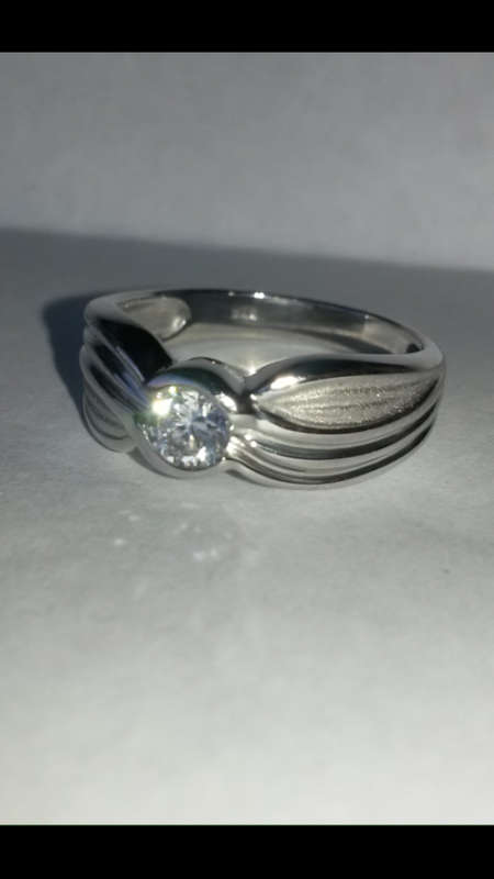 AN ELEGANT STERLING SILVER RING SET WITH CUBIC ZIRCONIA