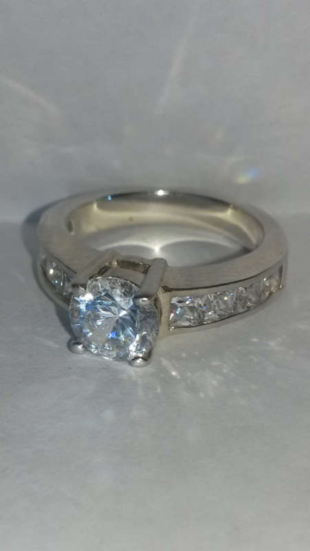 AN ELEGANT STERLING SILVER RING SET WITH CUBIC ZIRCONIA