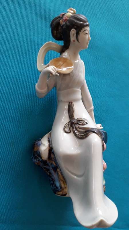 CERAMIC FIGURINE OF A SEATED GEISHA GIRL