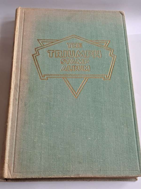 `The Triumph Stamp Album` -  empty (no stamps) - +/- 23cm x 19cm