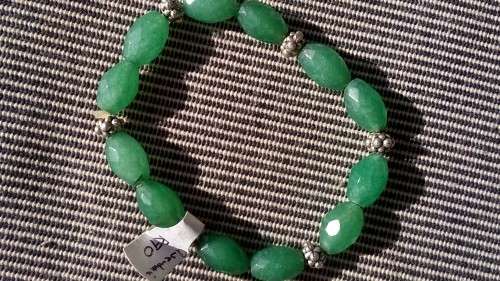 GREEN ADVENTURINE GEMMSTONE BRACELET.  STRUNG ON ELASTIC, WITH METAL BEADS.
