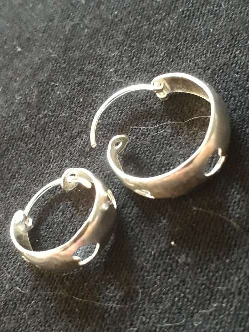 SOLID STERLING SILVER EARRINGS WITH HEART SHAPES.
