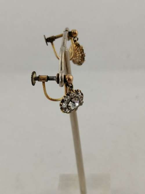 A vintage pair of brass and rhinestone screw back earrings
