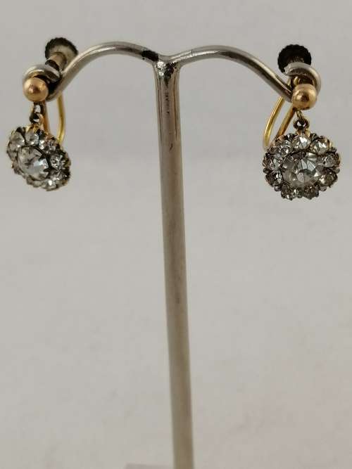A vintage pair of brass and rhinestone screw back earrings