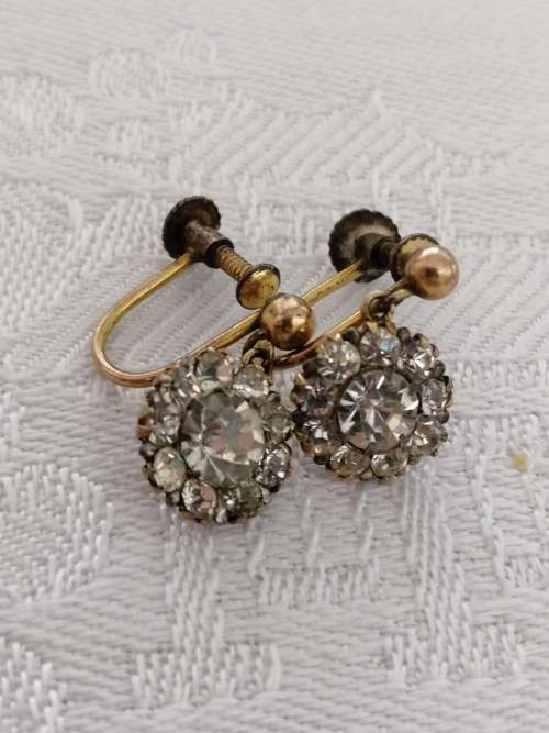 A vintage pair of brass and rhinestone screw back earrings