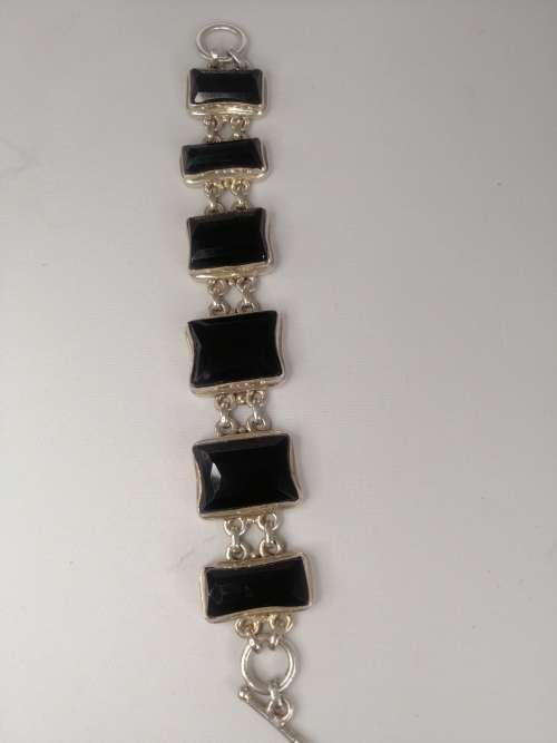 A STERLING SILVER BRACELET WITH BLACK FANCY CUT BLACK STONES