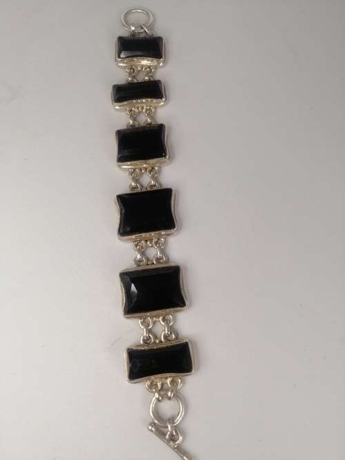 A STERLING SILVER BRACELET WITH BLACK FANCY CUT BLACK STONES