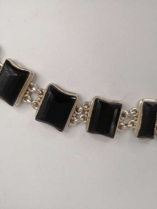 A STERLING SILVER BRACELET WITH BLACK FANCY CUT BLACK STONES