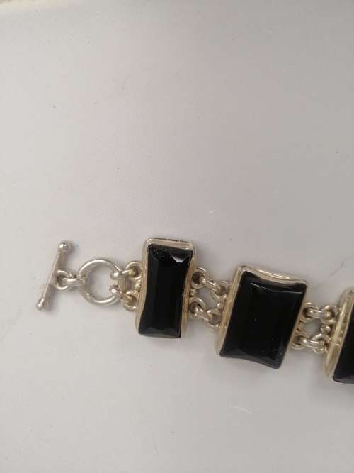 A STERLING SILVER BRACELET WITH BLACK FANCY CUT BLACK STONES