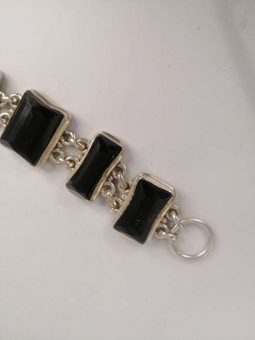 A STERLING SILVER BRACELET WITH BLACK FANCY CUT BLACK STONES