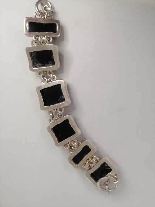 A STERLING SILVER BRACELET WITH BLACK FANCY CUT BLACK STONES