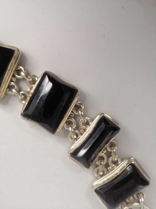 A STERLING SILVER BRACELET WITH BLACK FANCY CUT BLACK STONES