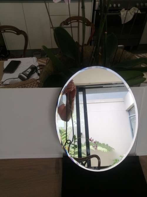 A VINTAGE OVAL FRAMELESS BEVELLED MIRROR