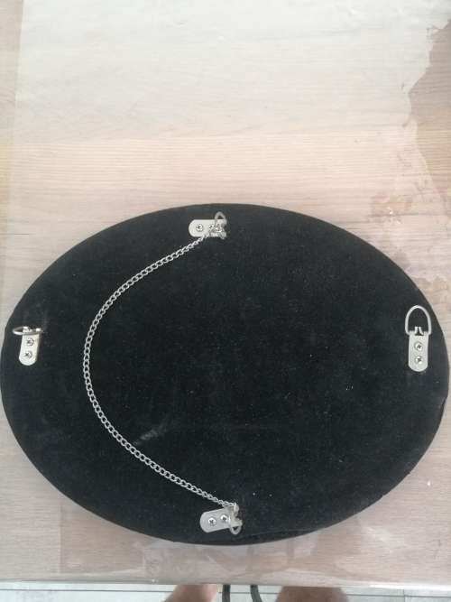 A VINTAGE OVAL FRAMELESS BEVELLED MIRROR