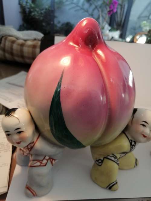 TWO CHINESE PORCELIAN STATUETTES CHILDREN CARRYING A RIPE PEACH