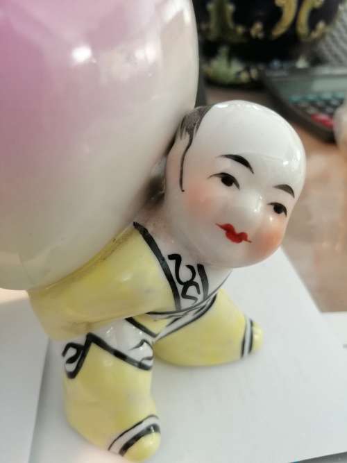 TWO CHINESE PORCELIAN STATUETTES CHILDREN CARRYING A RIPE PEACH