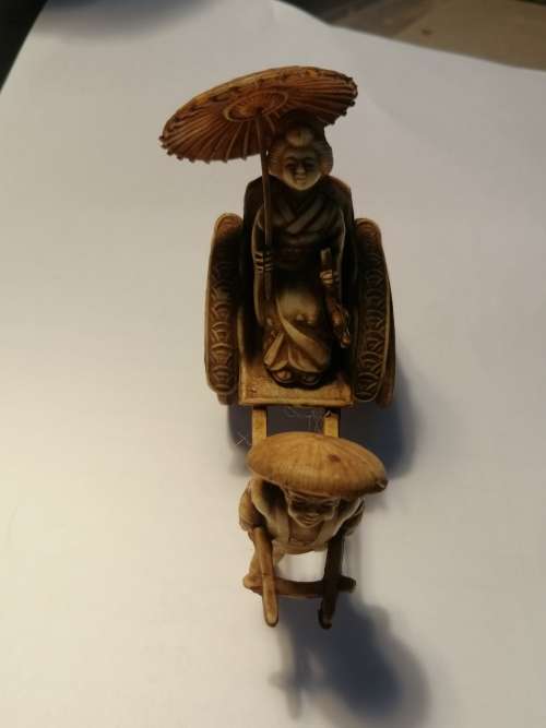 A VINTAGE JAPANESE CELLULIOD FIGURINE OF A GEISHA GIRL ON A RICKSHAW