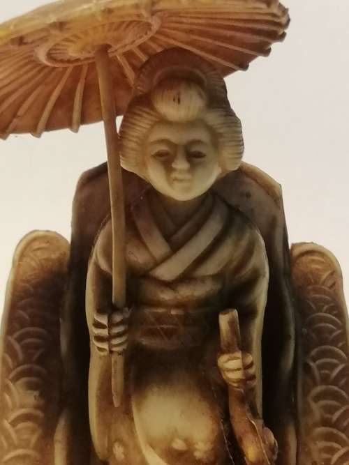 A VINTAGE JAPANESE CELLULIOD FIGURINE OF A GEISHA GIRL ON A RICKSHAW
