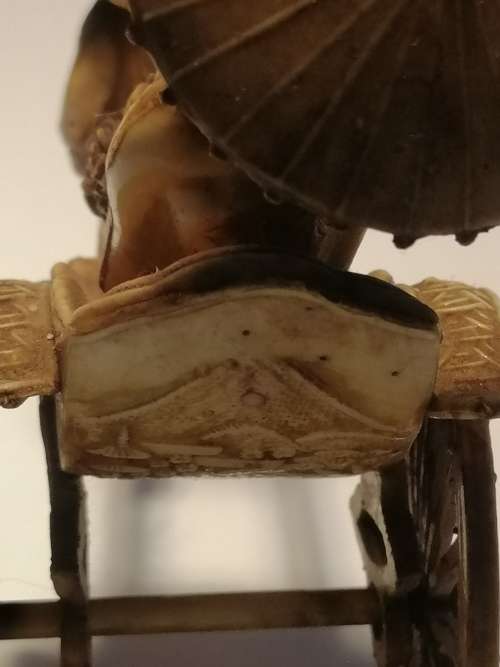 A VINTAGE JAPANESE CELLULIOD FIGURINE OF A GEISHA GIRL ON A RICKSHAW