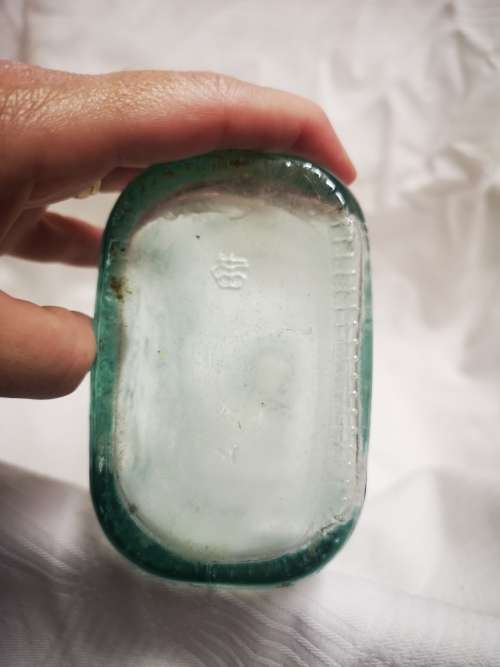 Vintage glass bottle with sun on one side and moon on the other