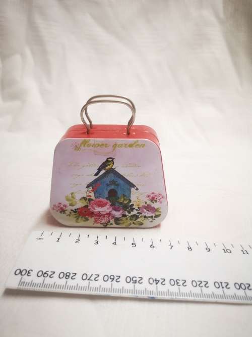 Small "flower garden" tin, opens like a suitcase. Perfect for a dolls luggage.