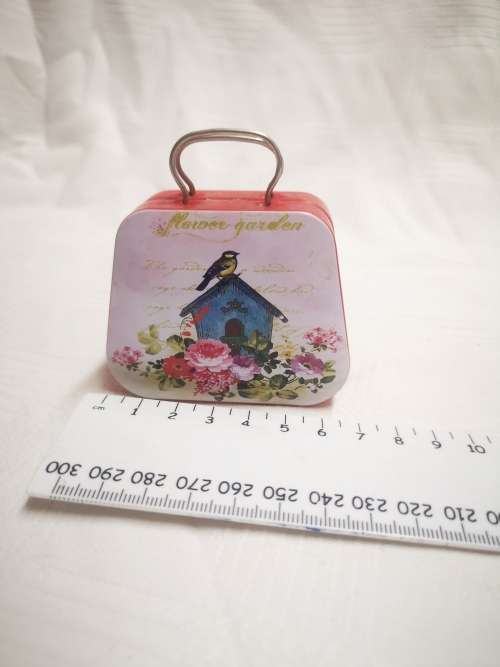 Small "flower garden" tin, opens like a suitcase. Perfect for a dolls luggage.