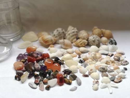 Big lot of sea shells and some semi-precious stones in a glass bottle.
