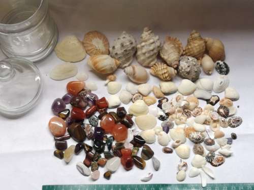 Big lot of sea shells and some semi-precious stones in a glass bottle.
