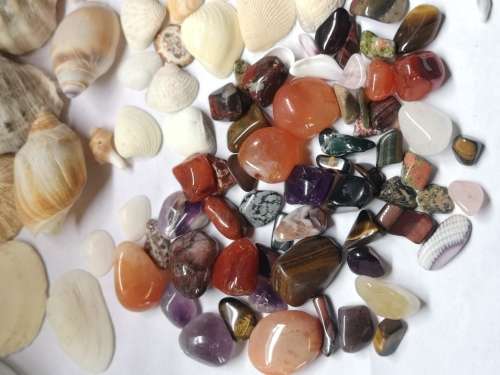 Big lot of sea shells and some semi-precious stones in a glass bottle.