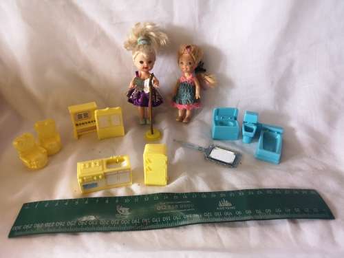 Two small Barbie's sister-like dolls with toy furniture.