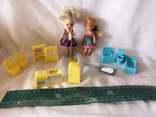 Two small Barbie's sister-like dolls with toy furniture.