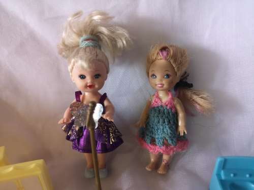 Two small Barbie's sister-like dolls with toy furniture.