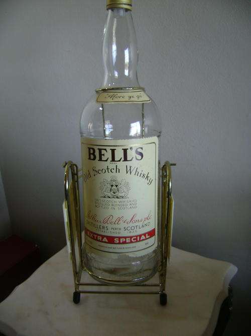 THIS LARGE BELLS SCOTCH WISKY BOTTLE ON BRASS STAND - VERY GOOD CONDITION