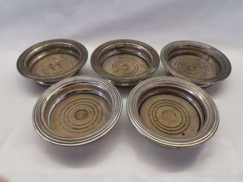 FIVE VICTORIAN SILVERPLATE BOTTLE COASTERS