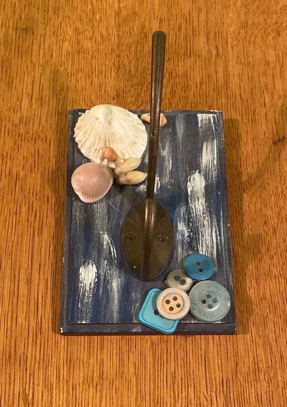 COAT / HAT WALL HOOKS on SMALL PAINTED PANEL with SHELLS & BUTTONS.