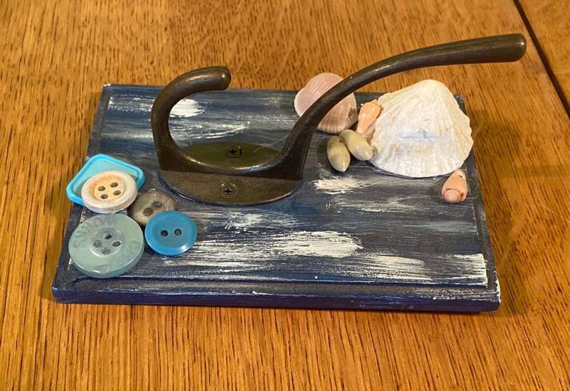 COAT / HAT WALL HOOKS on SMALL PAINTED PANEL with SHELLS & BUTTONS.