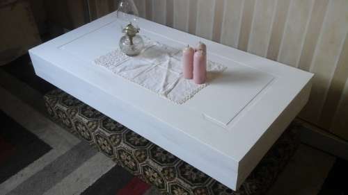 DEFINITLY DIFFERENT. A RECTANGULAR COFFEE TABLE ON A CARPETTED PLATFORM. VERY UNUSUAL