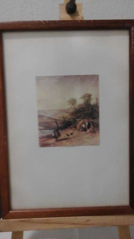 POSSIBLE PRINT OF A NATIVE HOMESTEAD HAS A GLOSSY WOODEN FRAME WITH A LARGE WHITE BORDER